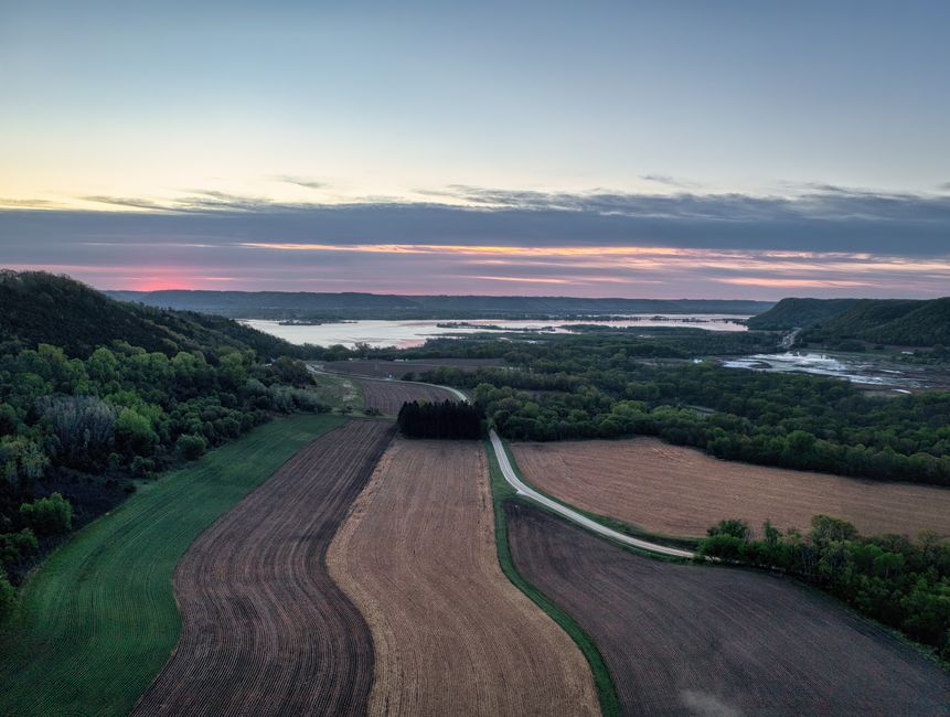 Rolling farmland along a river valley in eastern Iowa