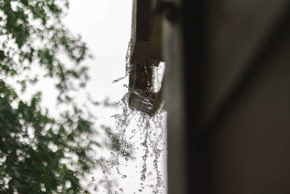 Rainwater overflowing from a gutter during a heavy downpour